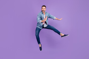 Full length body size photo man smiling jumping up practicing martial arts isolated pastel violet color background