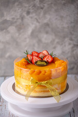 Fresh orange cake soft fudge decorated with orange pulp and strawberry for birthday cake on white stand cake.