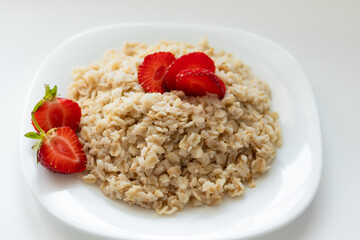 oatmeal with strawberries on a white plate, healthy food