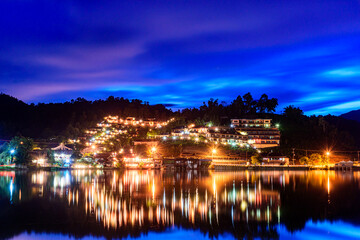 Fototapeta na wymiar Beautiful colorful twilight sky and reflecting water at Ban Rak Thai the village is surrounded by mountain in Mae Hong Son, Thailand.