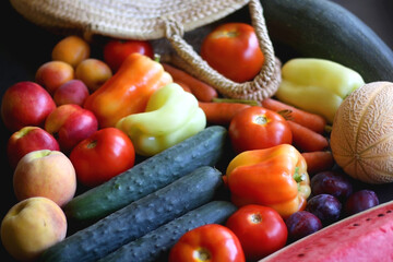 Straw bag and various seasonal fruit and vegetable. Selective focus.