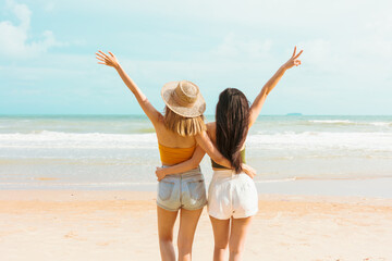 Two Asian women in summer casual clothes play in the sea on vacation in tropical country.