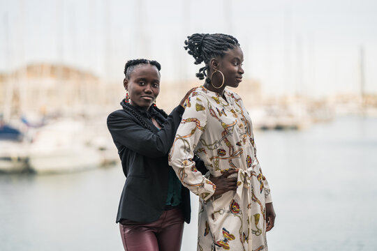 Relaxed black girl friends bonding and looking at camera