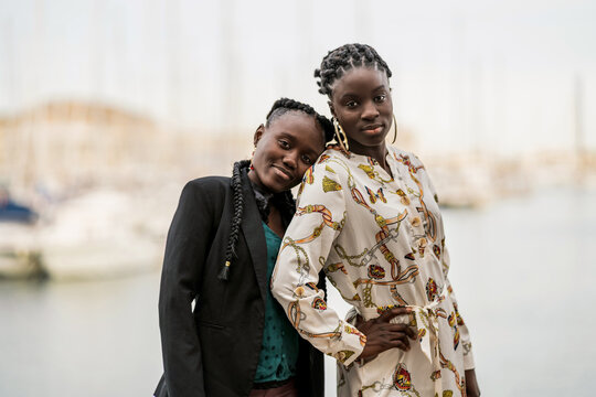 Relaxed black girl friends bonding and looking at camera