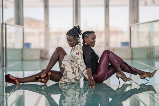Relaxed black girl friends bonding and looking away
