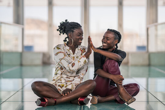Relaxed black girl friends bonding and looking at each other