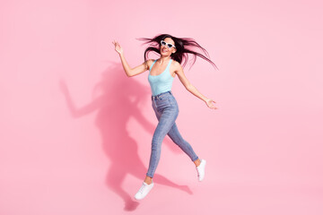 Full length body size view of attractive cheerful thin girl jumping going good mood isolated over pink pastel color background