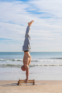 Man in handstand on parallel bars on coast