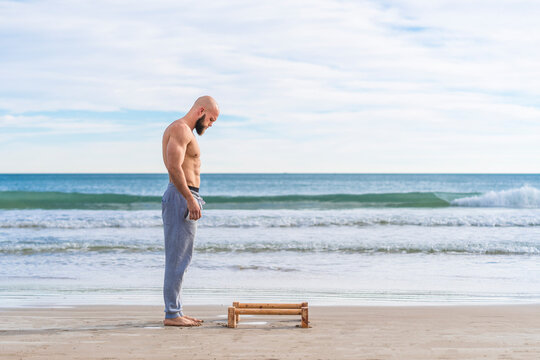 Man in working out on parallel bars on coast