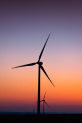 Fototapeta na wymiar Wind Turbines producing renewable energy at sunset 