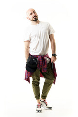 Stylish young modern man in casual clothes looking up with skeptical expression. Full body portrait isolated on white background