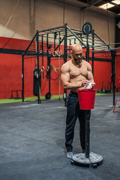 Bearded athlete applying chalk on hands