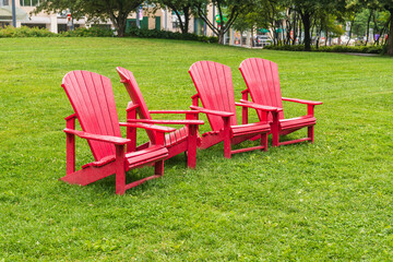 Colorful armchairs (muskoka chairs) on the green  lawn of a public park in Toronto.