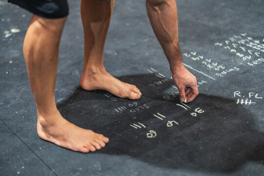 Crop athlete making notes on floor