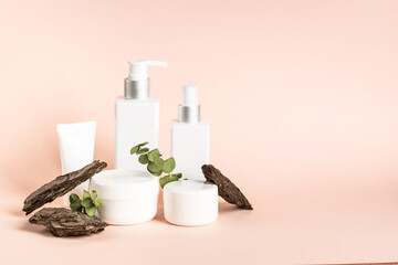 Natural cosmetic concept at pink background. Skincare product with natural leaves and tree bark.