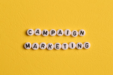 Alphabet letters with text CAMPAIGN MARKETING isolated on yellow background