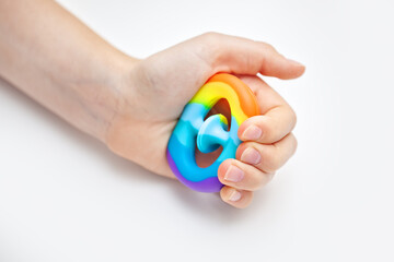 Silicone toy antistress in the hands of a teenager. Anti-stress colorful toy. New trend. Colorful anti stress sensory toy fidget push pop it. - obrazy, fototapety, plakaty