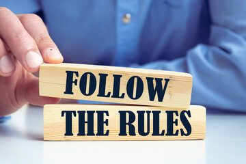 Follow The Rules word written on wood block. Follow The Rules text on table, concept.