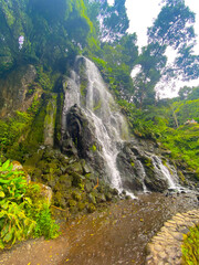 Beautiful waterfall surrounded by a green landscape in Sao Miguel, Azores.