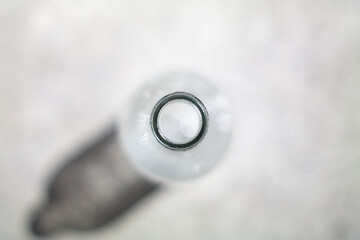 Clear empty glass bottle neck close up shot shallow depth of field top view
