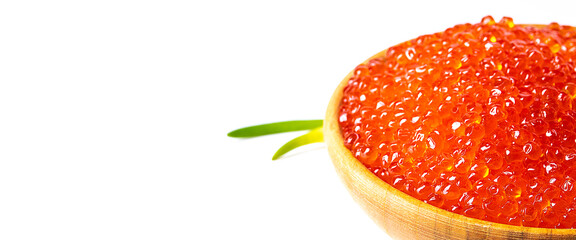 Red caviar in a wooden cup on a white background with a spoon and green onions. A large pile of bright caviar. Fresh delicious caviar. Isolated. A place for advertising, logo, label, layout, mockup.