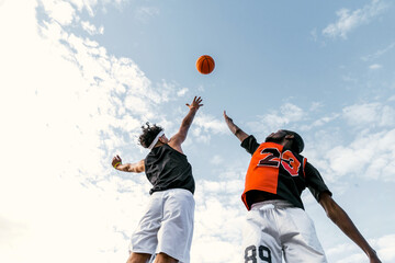 Black men playing street basketball in city