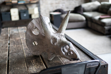 Artificial dinosaur skull on the table as an interior decoration © elenarostunova