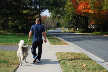 Man walking dog in residential neighborhood