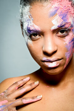 Ethnic woman with paint on face in studio
