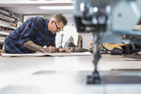 Man in workshop with old sewing machine at workbench