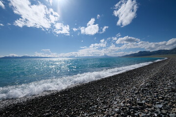 coastline of Sayram Lake. beautiful blue rushing water on sunny day. Travel destination of Xinjiang China