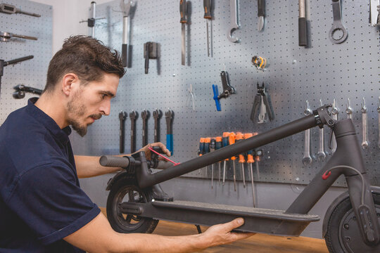 Mechanic assembling electric scooter in garage