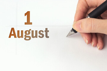 August 1st . Day 1 of month, Calendar date. The hand holds a black pen and writes the calendar...