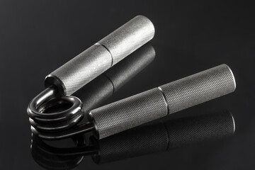 Steel wrist expander on a dark background.