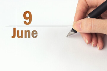 June 9th. Day 9 of month, Calendar date. The hand holds a black pen and writes the calendar date....