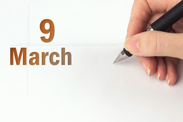 March 9th. Day 9 of month, Calendar date. The hand holds a black pen and writes the calendar date....