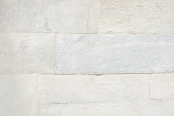 Old wall of white rectangular marble slabs