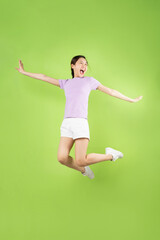 Fototapeta na wymiar Full body Young Asian girl jumping, isolated on green background