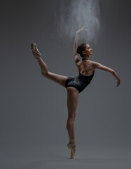 Graceful ballerina spraying dust and dancing inside studio © Fxquadro