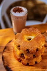 rocones rellenos de bocadillo sobre nandeja de madera con bebida de chocolate