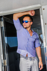 Handsome man wearing blue clothes posing in the boat