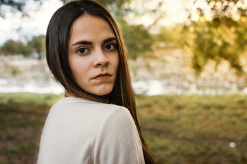 Retrato de joven mujer seria al aire libre