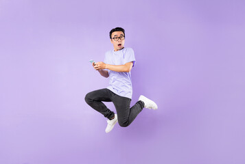 Portrait of a jumping asian man, isolated on purple background