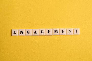Square letters with text ENGAGEMENT isolated on yellow background
