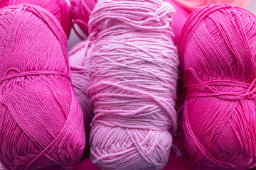 Large size pink and purple balls of elongated woolen acrylic or nylon yarn, taken in full frame close-up on the theme of hobby, hand-made or knitting