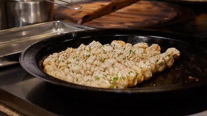 big frying pan with sheng jian bao-traditional chinese pan fried dumplings with minced pork shrimp and vegetables in Shanghai China, Cantonese food,pan-fried