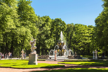 Obraz premium View of the Summer Garden in St. Petersburg with a crown fountain, sculptures and walking tourists. Saint Petersburg, Russia
