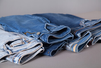 Fashion different jeans on gray background.
