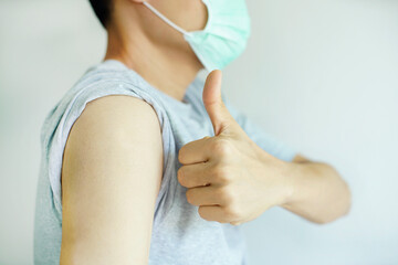 A man wear face mask showing his shoulder with thumb up on white background, Feeling good and ok                                                                                    