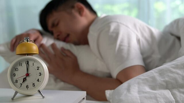 Young Asian man hates waking up early in the morning.